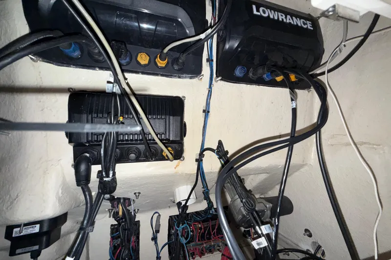 Slide: The Image of Electrical wiring and Lowrance equipment inside a 2014 Mako 284 Center Console boat. - 29