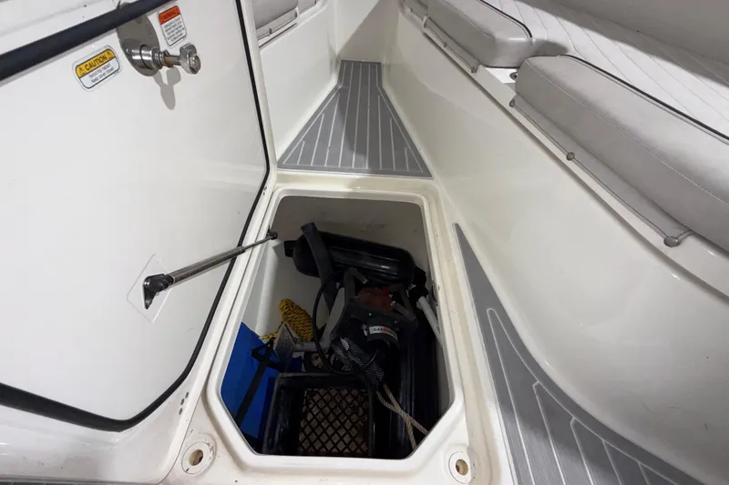Slide: The Image of Storage compartment of a 2014 Mako 284 Center Console boat, open with equipment inside. - 33