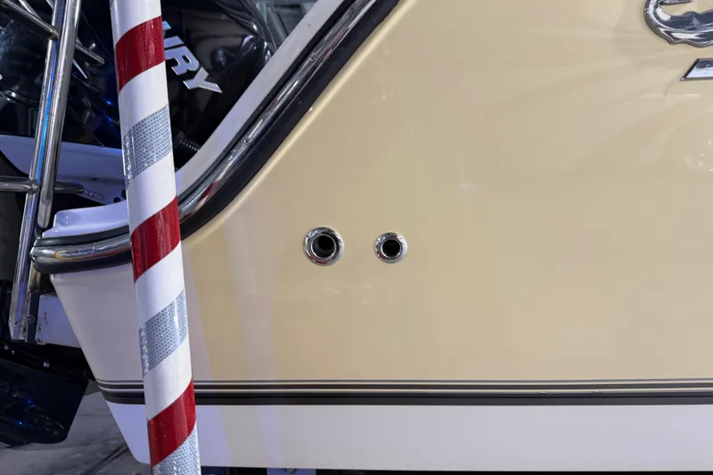 Slide: The Image of 2014 Mako 284 Center Console boat side view with chrome fittings and striped pole. - 36