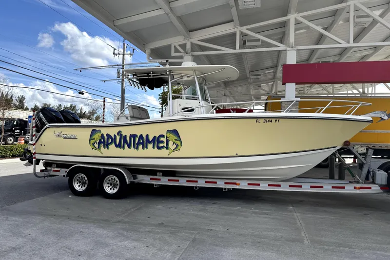 Slide: The Image of 2014 Mako 284 Center Console with twin 250 horsepower engines in a storage facility. - 5