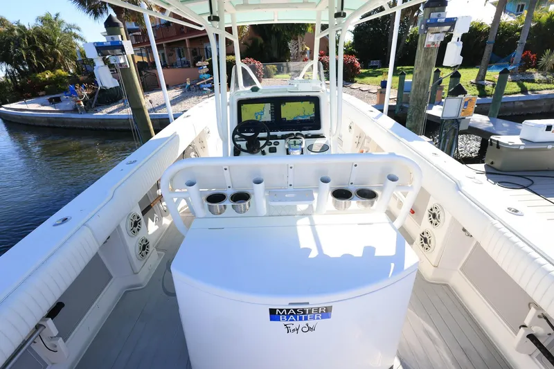 Slide: The Image of 2005 Jupiter 38 FS boat interior with steering console and cup holders, docked by a waterfront. - 10