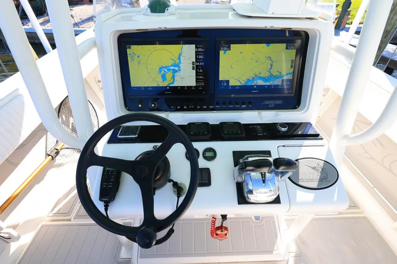 Slide: The Image of Control panel of a 2005 Jupiter 38 FS boat with navigation screens and steering wheel. - 12