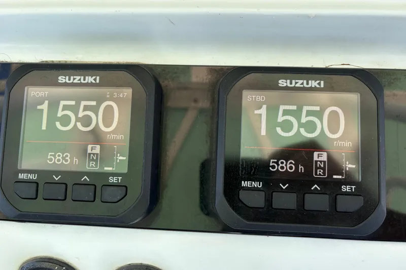 Slide: The Image of Suzuki engine displays showing 1550 RPM on a 2005 Jupiter 38 FS boat. - 13