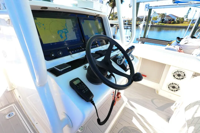 Slide: The Image of 2005 Jupiter 38 FS boat cockpit with navigation screens and steering wheel. - 15