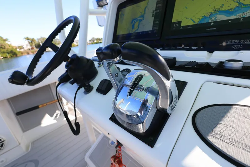 Slide: The Image of Control panel of a 2005 Jupiter 38 FS boat with steering wheel and navigation screens. - 16