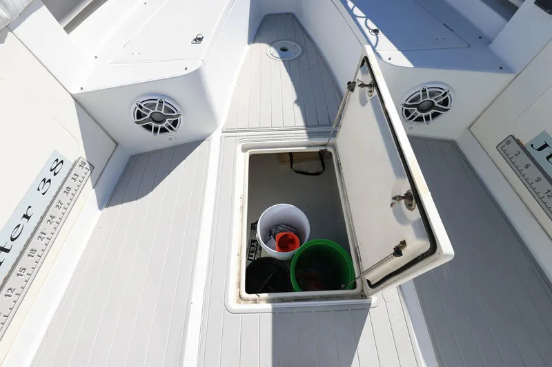Slide: The Image of Open storage compartment on 2005 Jupiter 38 FS boat deck with buckets inside. - 27