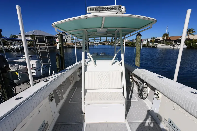 Slide: The Image of 2005 Jupiter 38 FS boat docked in a sunny marina, showcasing spacious deck and seating. - 33