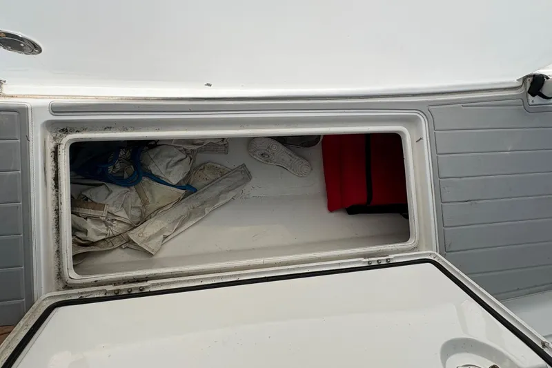 Slide: The Image of Open storage compartment on a 2005 Jupiter 38 FS boat, containing ropes and gear. - 38