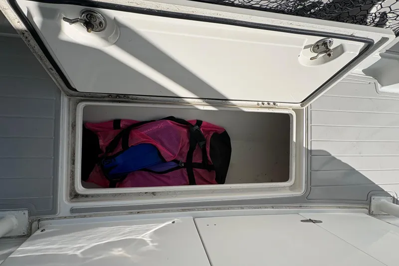 Slide: The Image of Open storage compartment on 2005 Jupiter 38 FS boat with pink bag inside. - 39