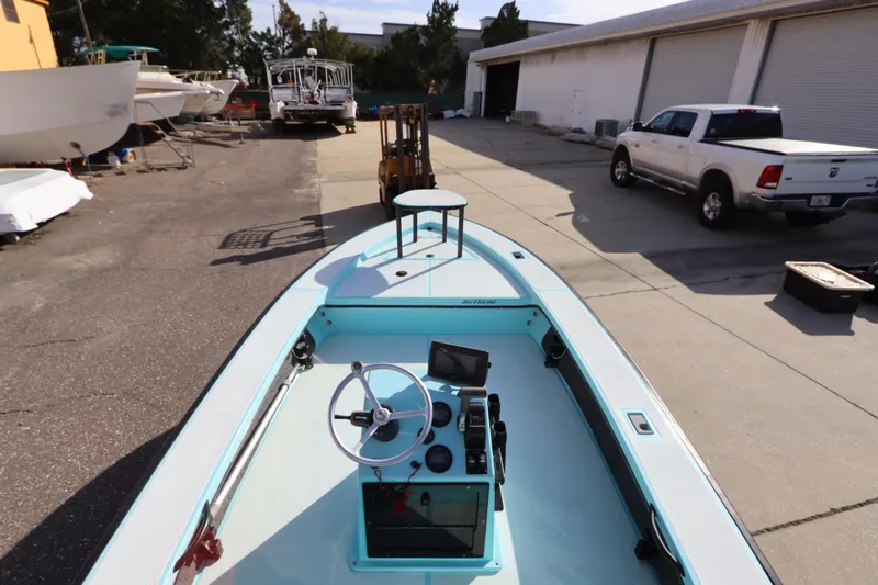 Slide: The Image of 1996 Silver King Signature 16 boat in a marina with parked vehicles and boats. - 14