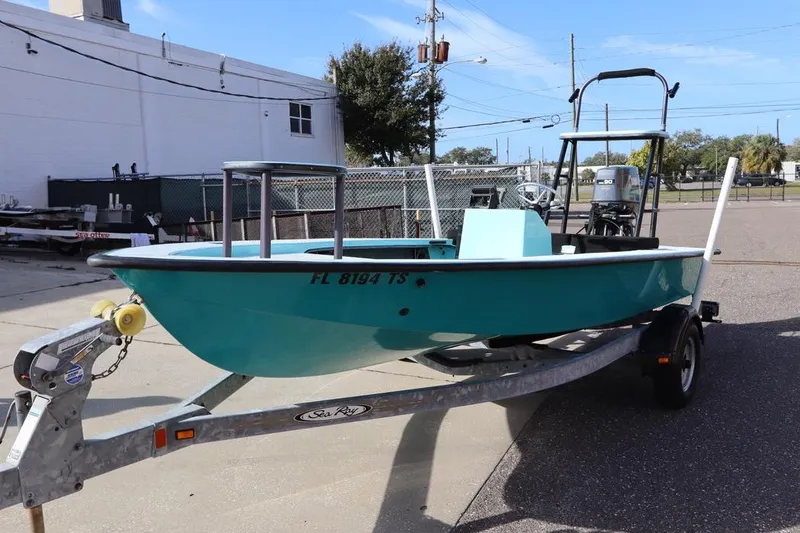 Slide: The Image of 1996 Silver King Signature 16 boat on trailer, teal color, parked outdoors. - 3
