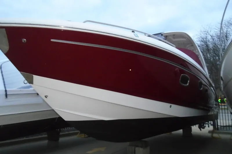 Slide: The Image of 2013 Chaparral 327 SSX boat docked by a waterfront house. - 1