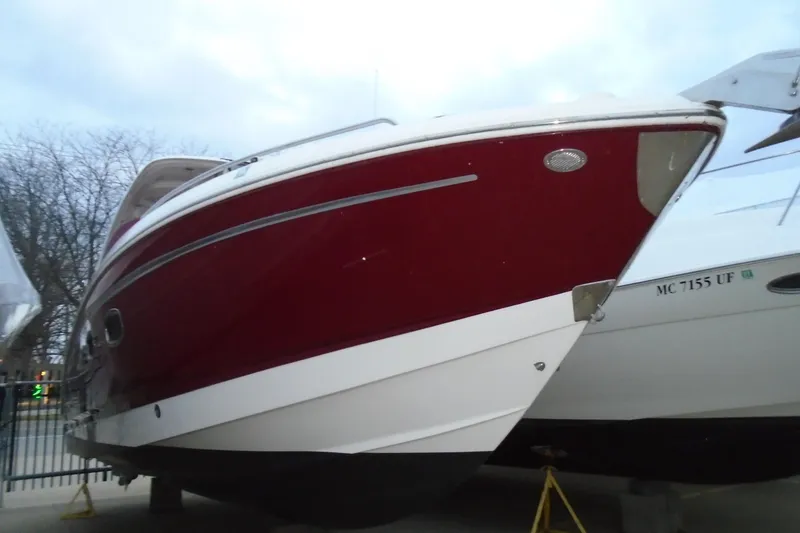 Slide: The Image of 2013 Chaparral 327 SSX boat docked by waterfront homes. - 2