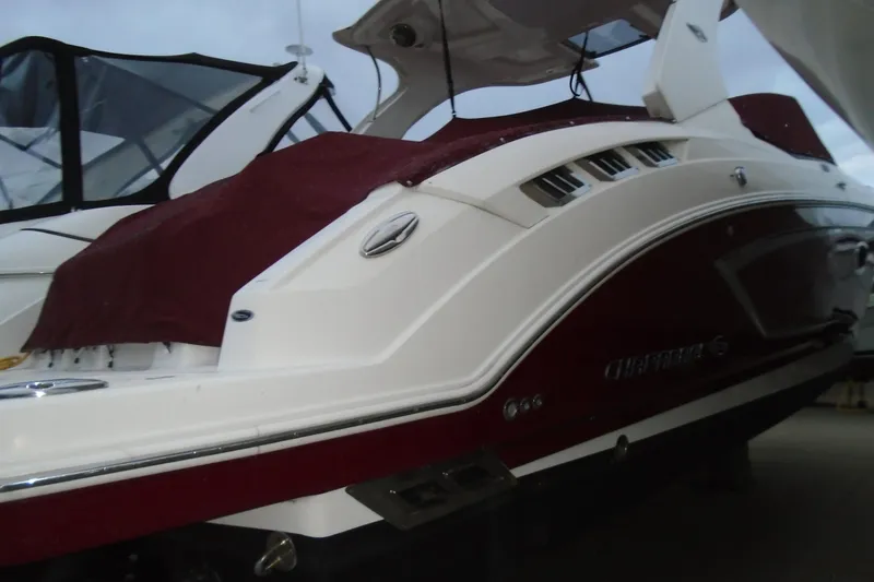 Slide: The Image of 2013 Chaparral 327 SSX boat with sleek red and white hull design. - 3
