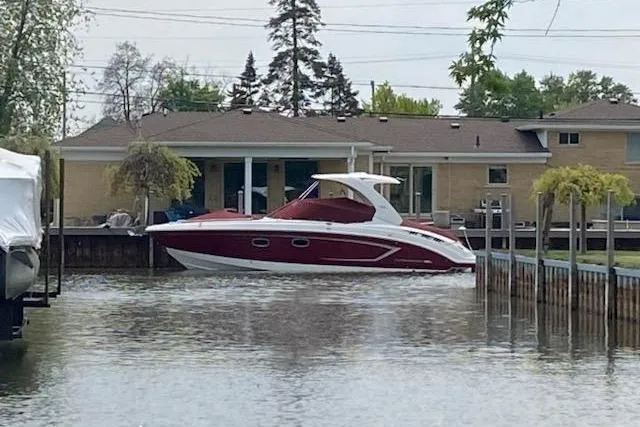 Slide: The Image of 2013 Chaparral 327 SSX boat docked near a waterfront house. - 42
