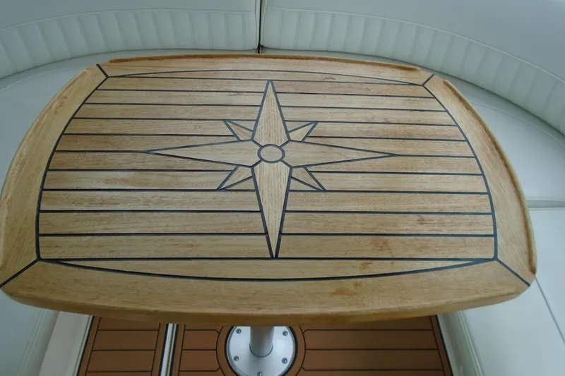 Slide: The Image of Wooden table with compass rose design on 2003 Cruisers Yachts 3470 Express. - 12