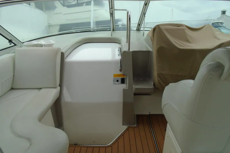 Slide: The Image of 2003 Cruisers Yachts 3470 Express interior with white seating and covered dashboard. - 13
