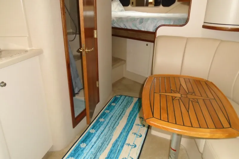 Slide: The Image of 2003 Cruisers Yachts 3470 Express interior with wooden table and cozy seating area. - 27