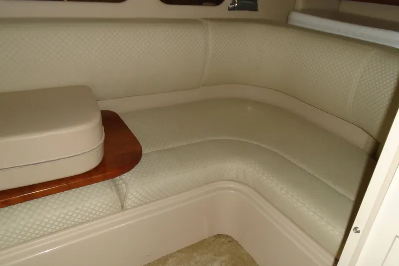 Slide: The Image of 2003 Cruisers Yachts 3470 Express interior with beige seating and wooden table. - 30