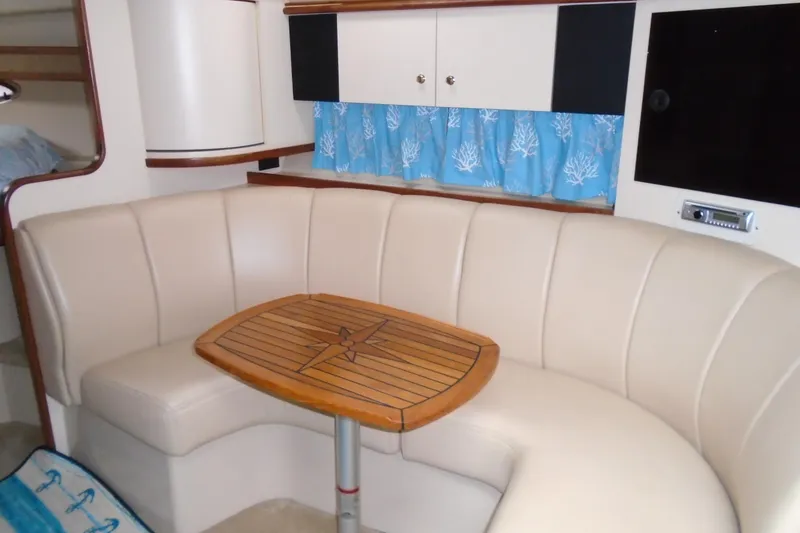 Slide: The Image of 2003 Cruisers Yachts 3470 Express interior with beige seating and wooden table. - 36