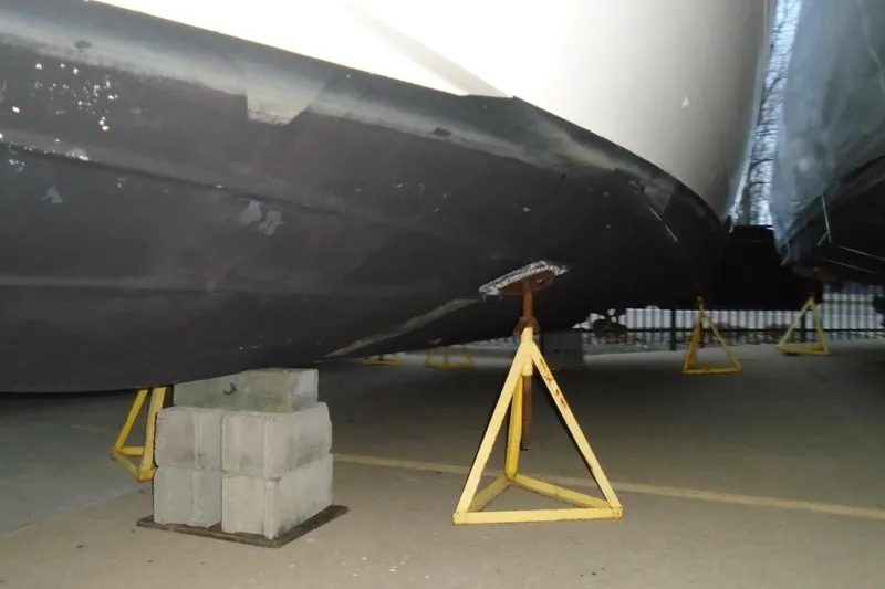 Slide: The Image of 2003 Cruisers Yachts 3470 Express on stands, hull view in storage. - 4