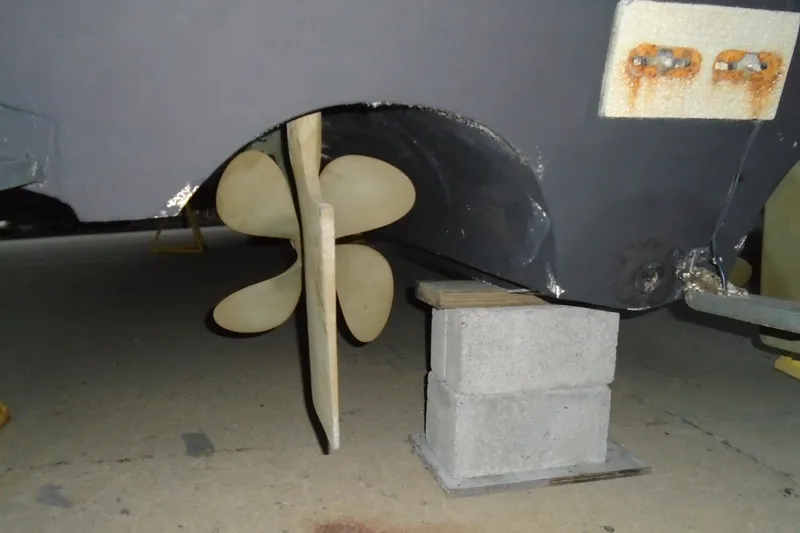Slide: The Image of 2003 Cruisers Yachts 3470 Express propeller and rudder on cinder blocks in a workshop. - 5