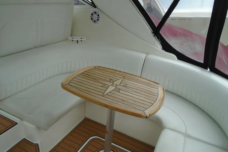 Slide: The Image of 2003 Cruisers Yachts 3470 Express interior with white seating and wooden table. - 11