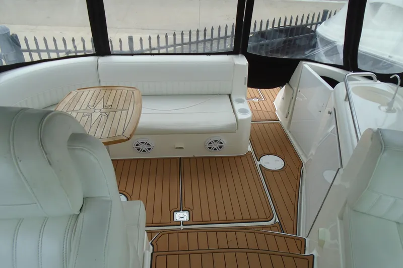 Slide: The Image of 2003 Cruisers Yachts 3470 Express interior with white seating and wooden flooring. - 25