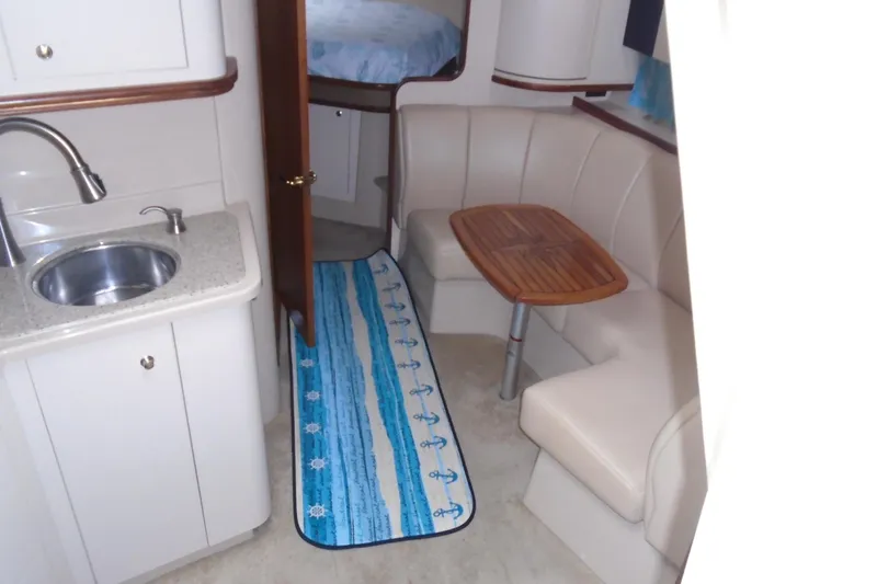 Slide: The Image of 2003 Cruisers Yachts 3470 Express interior with kitchenette, seating area, and nautical decor. - 26