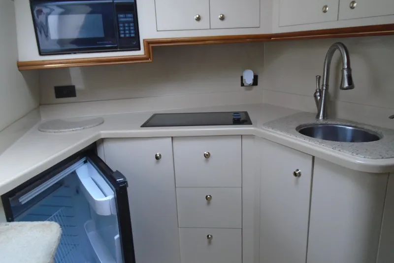 Slide: The Image of 2003 Cruisers Yachts 3470 Express kitchen with sink, stove, microwave, and open fridge. - 28