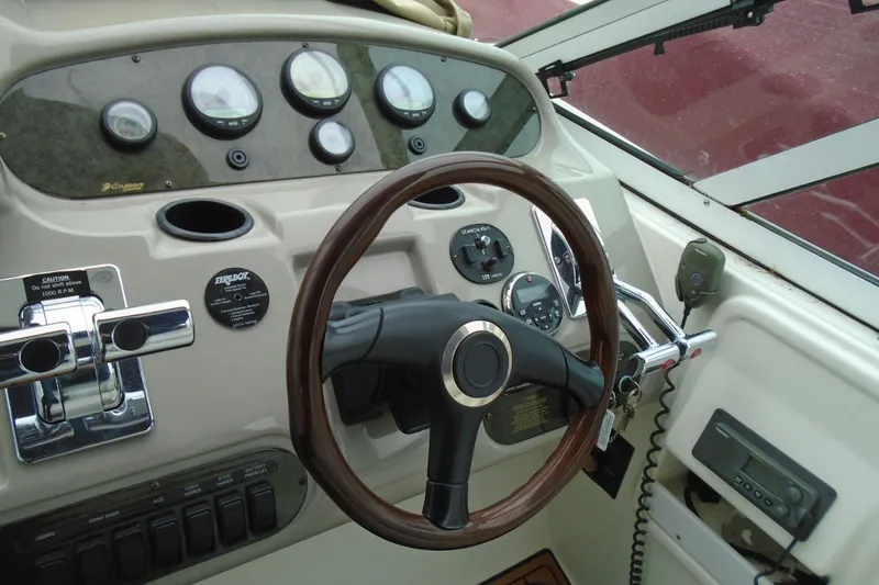 Slide: The Image of 2003 Cruisers Yachts 3470 Express helm with gauges, steering wheel, and controls. - 7