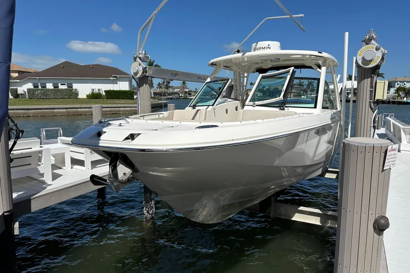 The Image of 2018 Boston Whaler 320 Vantage boat docked on a lift by the water. - 0