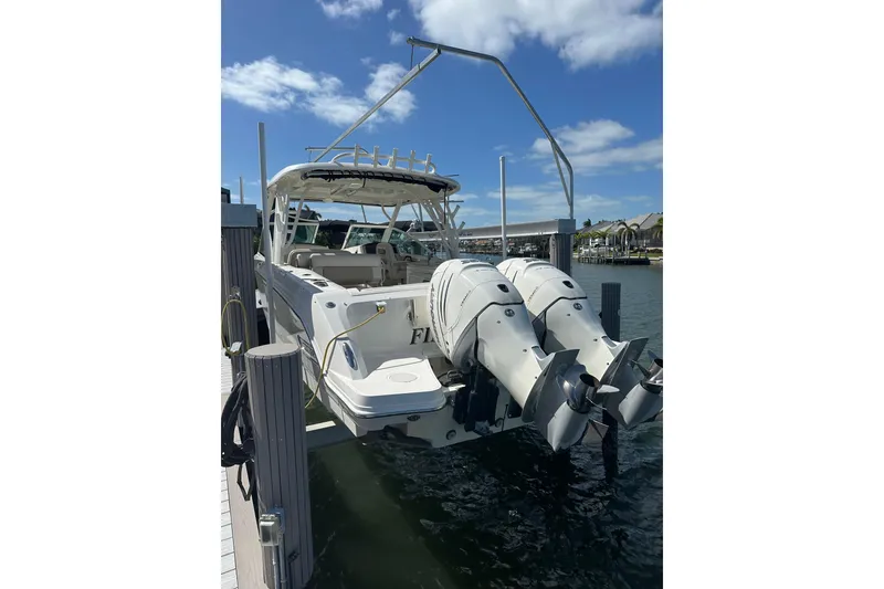 Slide: The Image of 2018 Boston Whaler 320 Vantage docked, featuring dual outboard engines under a clear blue sky. - 1