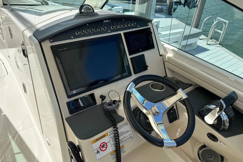 Slide: The Image of 2018 Boston Whaler 320 Vantage boat dashboard with steering wheel and navigation controls. - 12