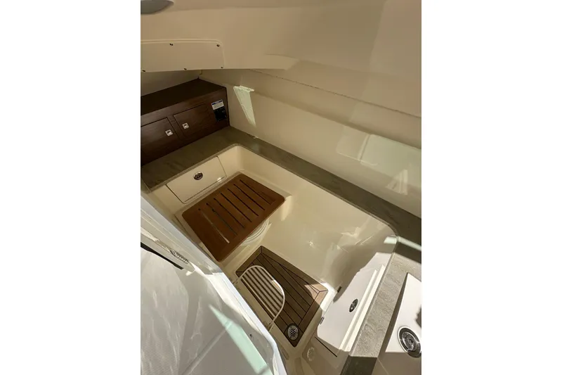 Slide: The Image of 2018 Boston Whaler 320 Vantage interior with wood accents and storage compartments. - 18