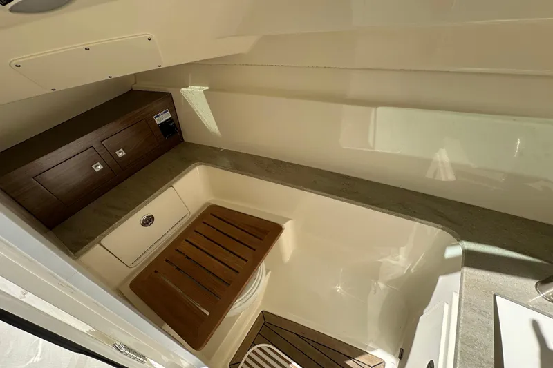Slide: The Image of 2018 Boston Whaler 320 Vantage interior with wood accents and storage compartments. - 3