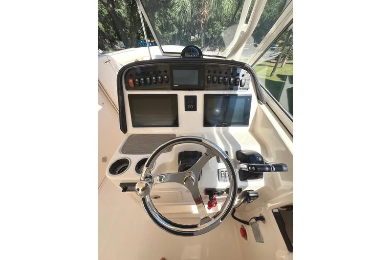 Slide: The Image of 2020 Grady-White Freedom 307 boat dashboard with steering wheel and control panels. - 17