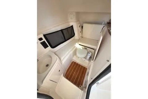 Slide: The Image of 2020 Grady-White Freedom 307 boat interior with compact bathroom and wooden flooring. - 23