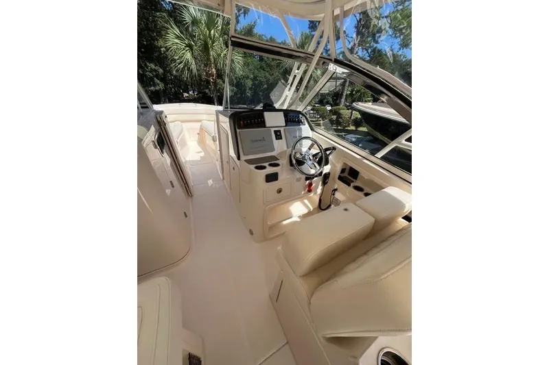 Slide: The Image of 2020 Grady-White Freedom 307 boat in blue, parked outdoors on gravel. - 4