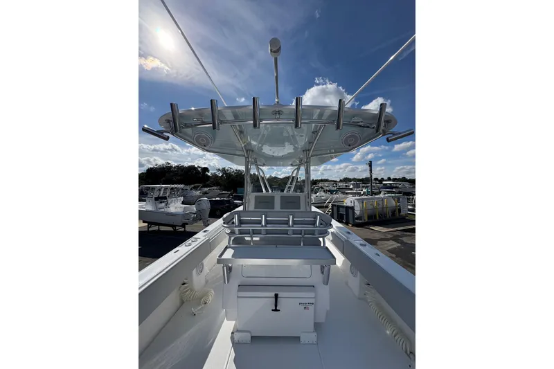 Slide: The Image of 2026 Contender 35 ST boat interior with modern helm and rod holders under a clear sky. - 8