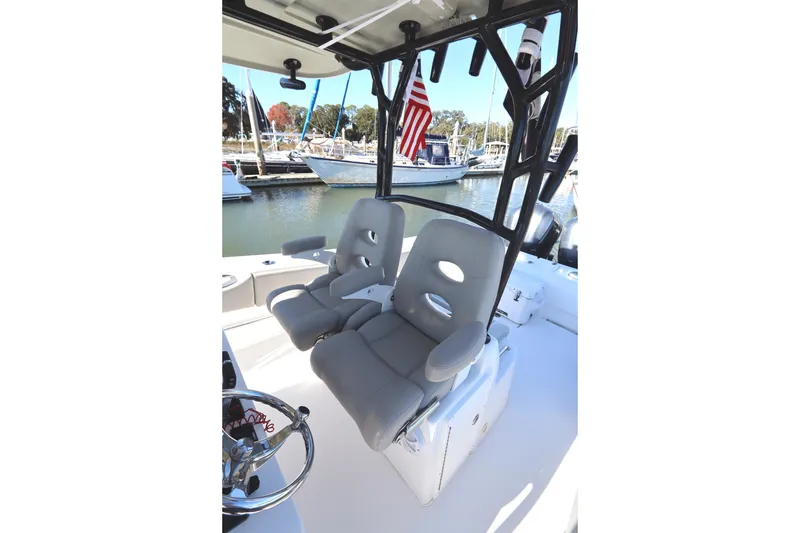 Slide: The Image of 2021 Cape Horn 31 T boat interior with dual seats and American flag in marina. - 40