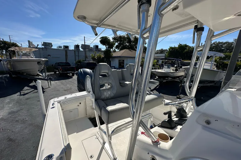 Slide: The Image of 2005 Topaz 24 Silverhawk boat interior with seating and control area, parked outdoors. - 10