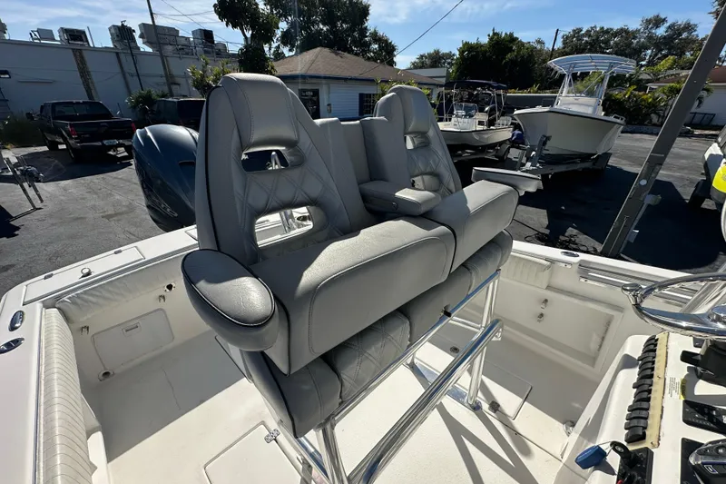 Slide: The Image of 2005 Topaz 24 Silverhawk boat with dual cushioned seats and sleek design in a sunny outdoor setting. - 11