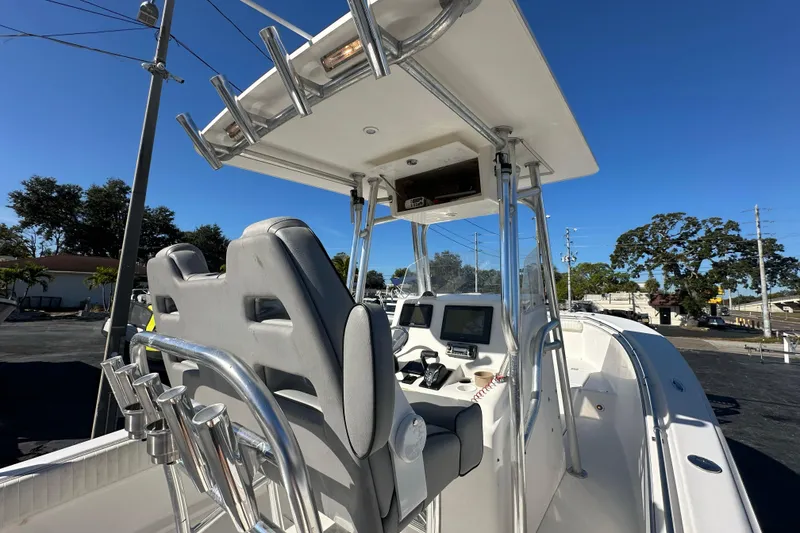 Slide: The Image of 2005 Topaz 24 Silverhawk boat interior with helm, seats, and navigation equipment under clear blue sky. - 13