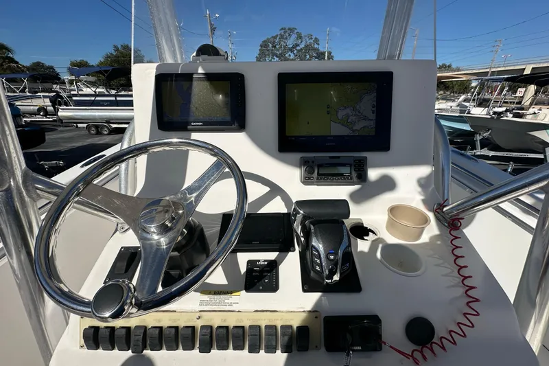 Slide: The Image of 2005 Topaz 24 Silverhawk boat dashboard with steering wheel and navigation screens. - 16