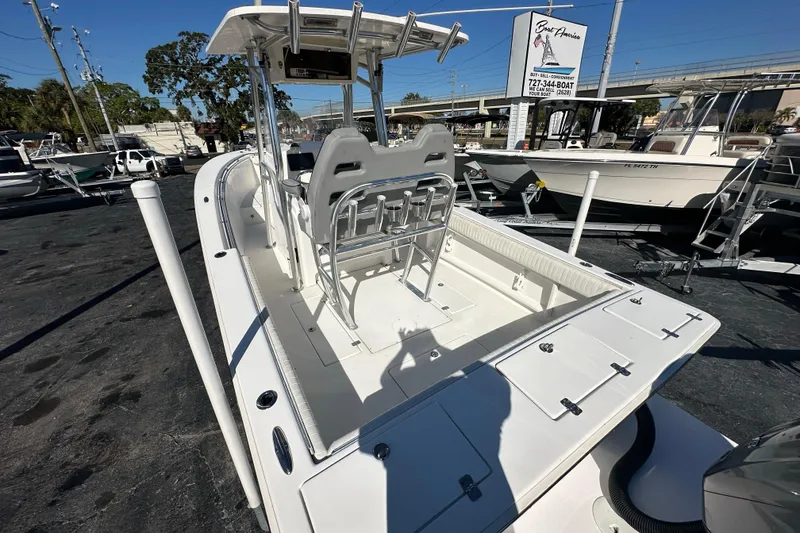 Slide: The Image of 2005 Topaz 24 Silverhawk boat with center console and seating, displayed outdoors. - 17