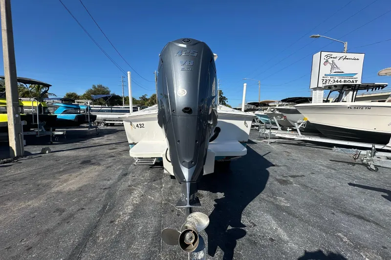 Slide: The Image of 2005 Topaz 24 Silverhawk boat with powerful outboard motor in a dealership lot. - 2