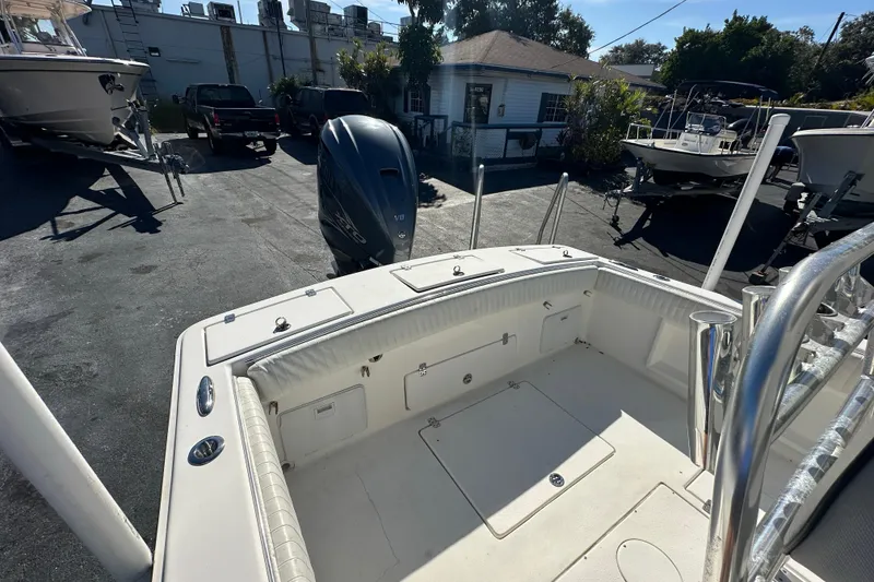 Slide: The Image of 2005 Topaz 24 Silverhawk boat with outboard motor in a sunny marina setting. - 20