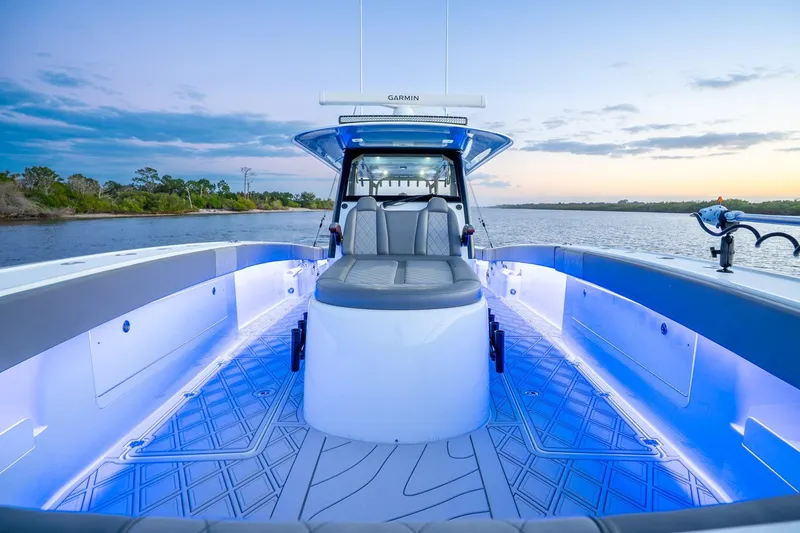 Slide: The Image of 2025 Freeman 43 boat interior with blue LED lighting on a serene waterway. - 14