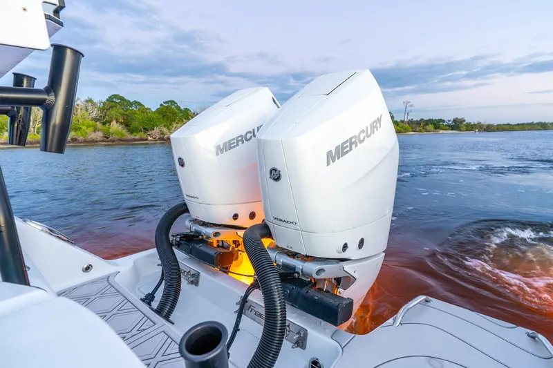 Slide: The Image of Twin Mercury outboard engines on a 2025 Freeman 43 boat, cruising on a scenic river. - 24